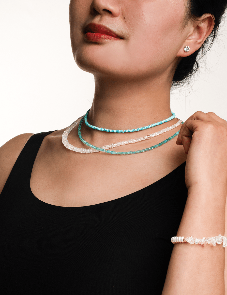 Model showcasing layered necklaces and a bracelet, highlighting unique design and elegant style.