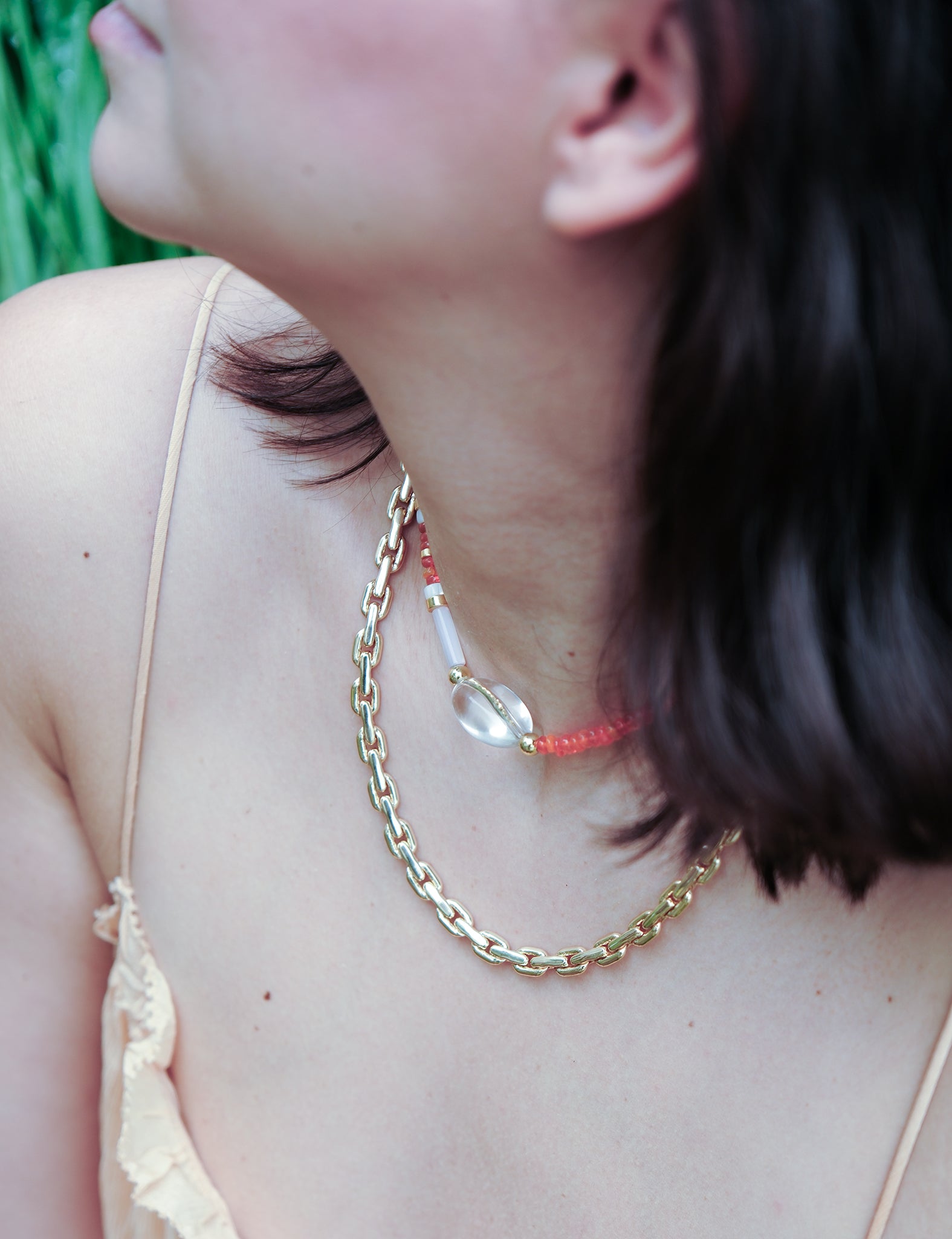 MIRA choker necklace featuring orange opal, clear quartz, and mother of pearl, worn elegantly by a model.