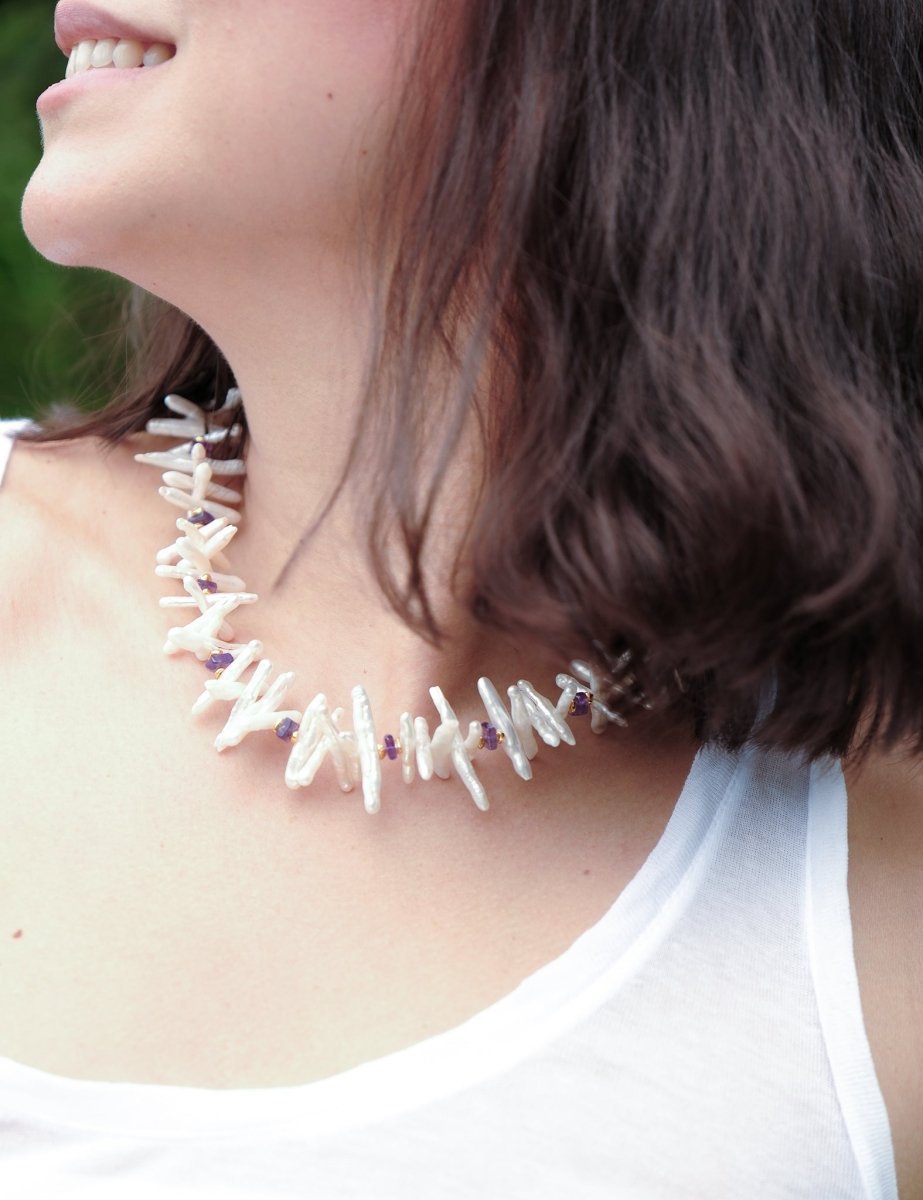 Close-up of a woman wearing the AURA DUO Amethyst Biwa-style stick pearl necklace with faceted beads.
