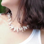 Close-up of a woman wearing the AURA DUO Amethyst Biwa-style stick pearl necklace with faceted beads.
