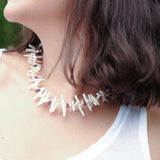 Close-up of a woman wearing the AURA DUO Amethyst Biwa-style stick pearl necklace with faceted beads.