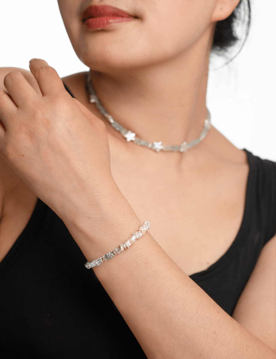 Model wearing AURA DUO Aquamarine Star Pearl Necklace and bracelet, showcasing their delicate design and star-shaped pearls.