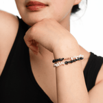 Model showcasing AURA DUO Black Opal Pearl Bracelet with Spacer Beads on wrist, highlighting elegance and energy.