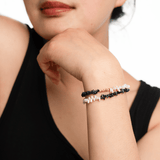 Model showcasing AURA DUO Black Opal Pearl Bracelet with Spacer Beads on wrist, highlighting elegance and energy.
