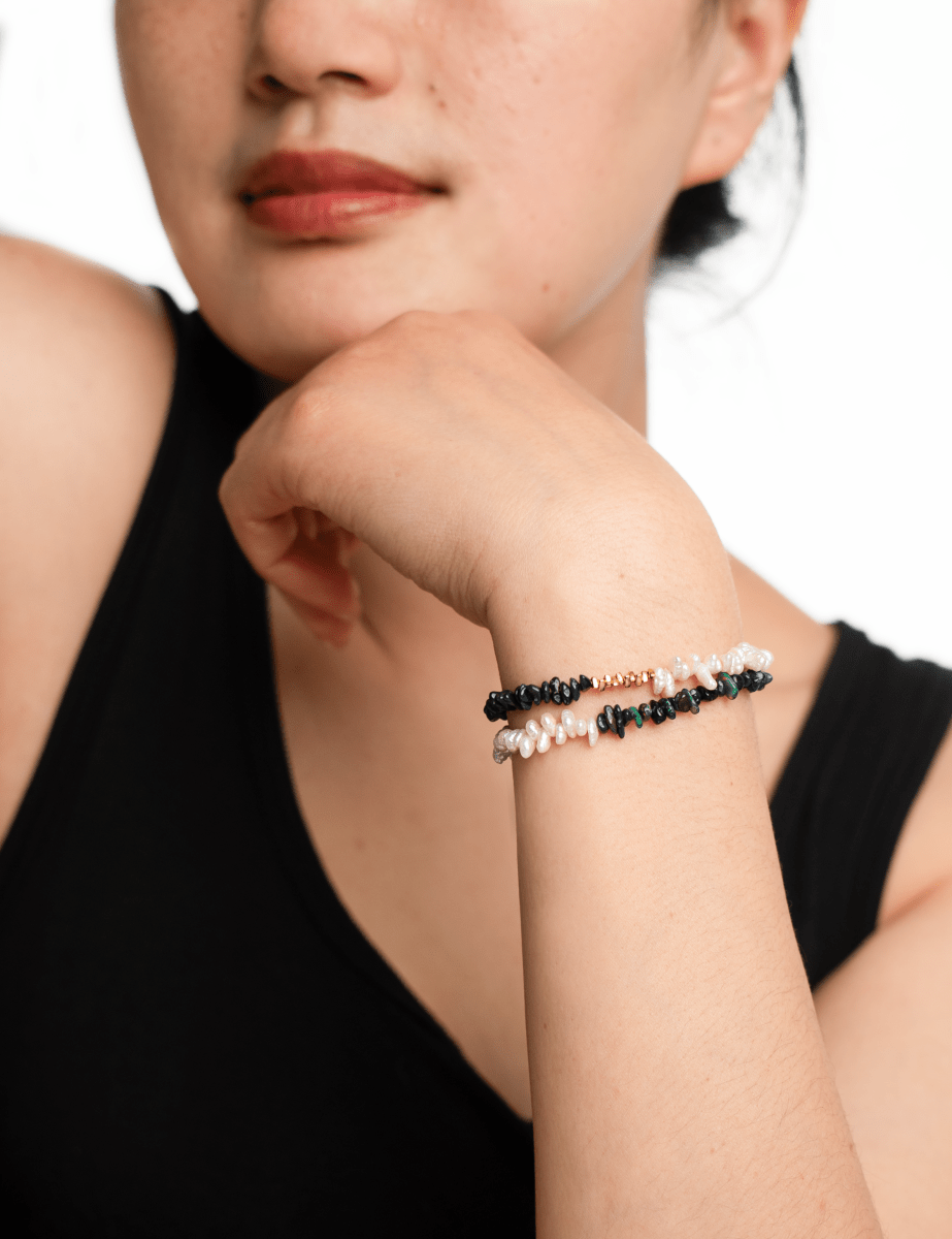 Model showcasing AURA DUO Black Opal Pearl Bracelet with Spacer Beads on wrist, highlighting elegance and energy.