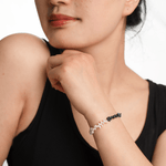 Woman wearing AURA DUO Black Opal Pearl Bracelet, showcasing its elegant design and mystical appeal.