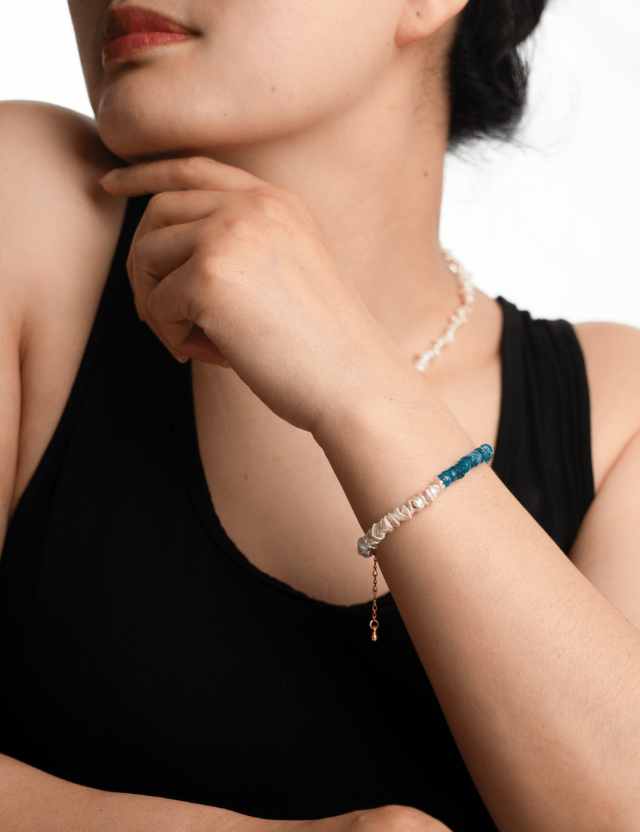Woman wearing AURA DUO Blue Apatite Pearl Bracelet showcasing its elegant design and vibrant colors.