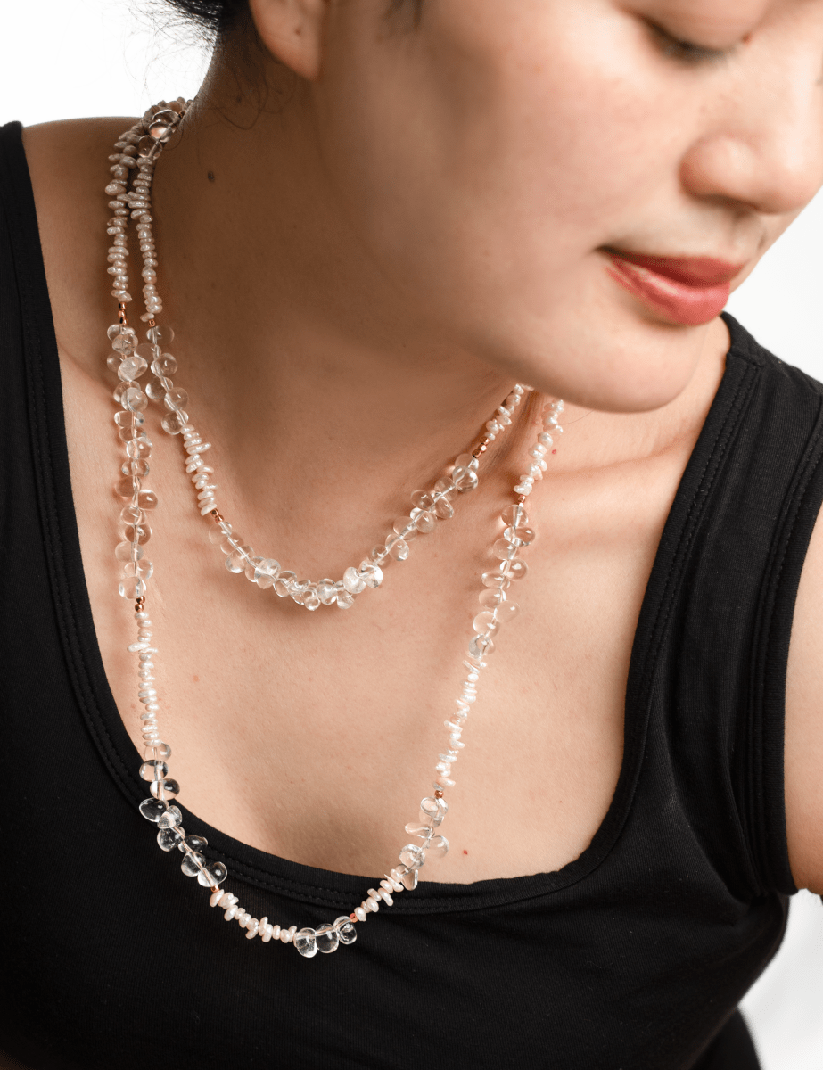 Woman wearing AURA DUO Clear Quartz Pearl Necklace, showcasing its elegant layers and natural beauty.