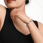 Woman wearing AURA DUO Gray Moonstone Star Pearl bracelet, showcasing its celestial charm and elegance.