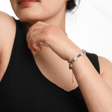 Woman wearing AURA DUO Gray Moonstone Star Pearl bracelet, showcasing its celestial charm and elegance.