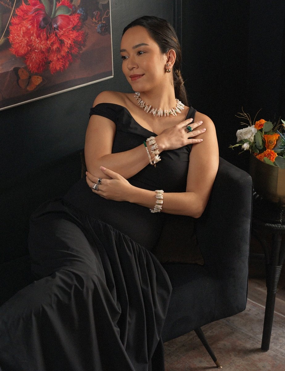 Woman in black dress showcasing elegant jewelry, including AURA DUO Green Agate Pearl Bracelets and earrings.