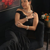 Woman in black dress showcasing elegant jewelry, including AURA DUO Green Agate Pearl Bracelets and earrings.