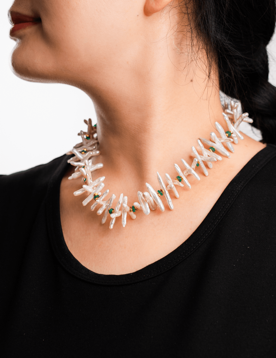 Close-up of a woman wearing a Biwa-style stick pearl necklace with green agate beads and gold-plated spacers.