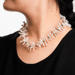 Close-up of a woman wearing a Biwa-style stick pearl necklace with green agate beads and gold-plated spacers.