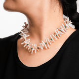 Close-up of a woman wearing a Biwa-style stick pearl necklace with green agate beads and gold-plated spacers.