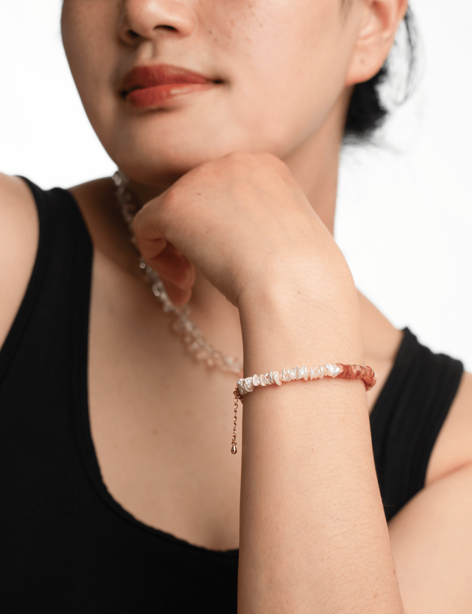 AURA DUO Sunstone Pearl Bracelet showcased on a model's wrist, featuring sunstone and pearls with spacer beads.