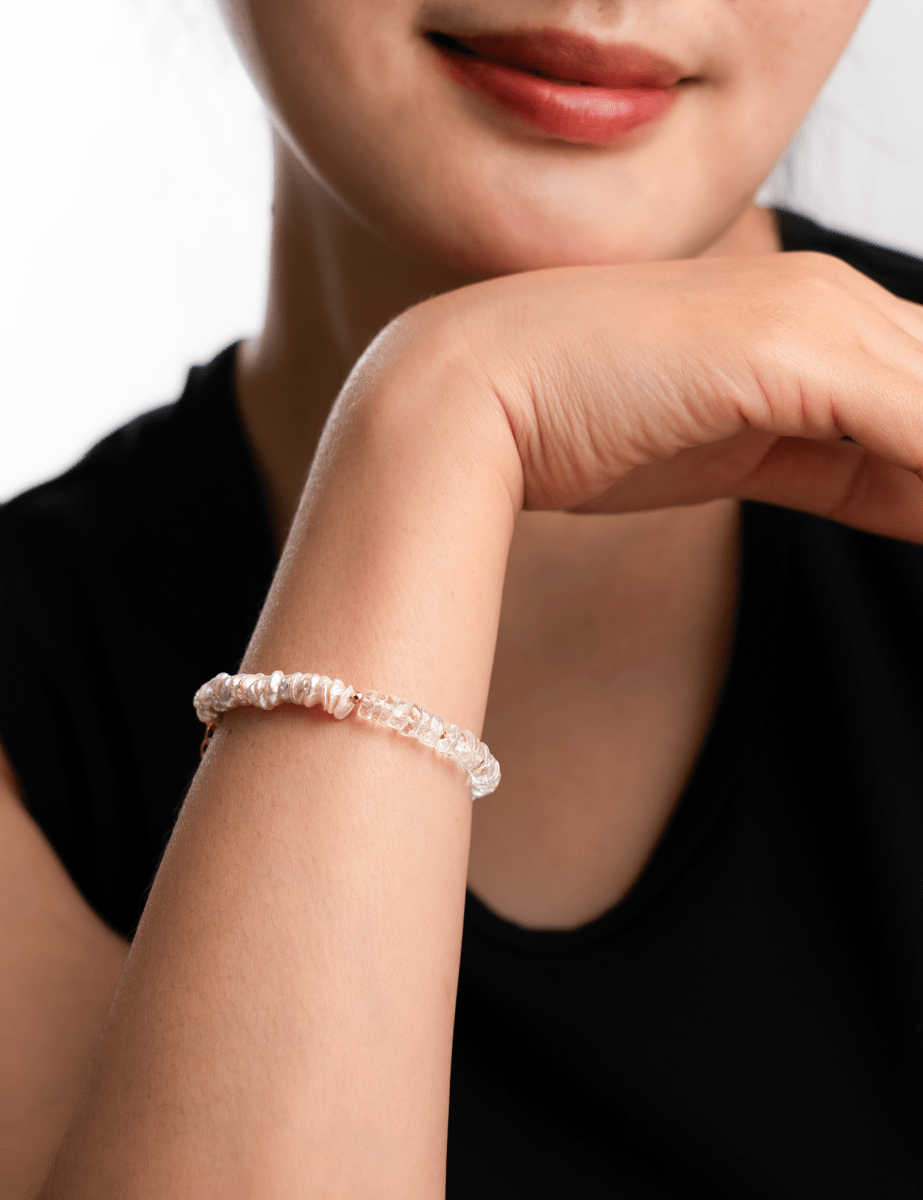 Close-up of a model wearing a crystal bracelet, showcasing elegance and style against a neutral background.