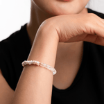 Close-up of a model wearing a crystal bracelet, showcasing elegance and style against a neutral background.