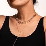Close-up of a woman wearing a colorful Rainbow Sapphire dainty necklace, showcasing vibrant hues and elegant design.