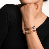 Model showcasing layered dainty bracelets, highlighting vibrant colors and intricate spacer beads.