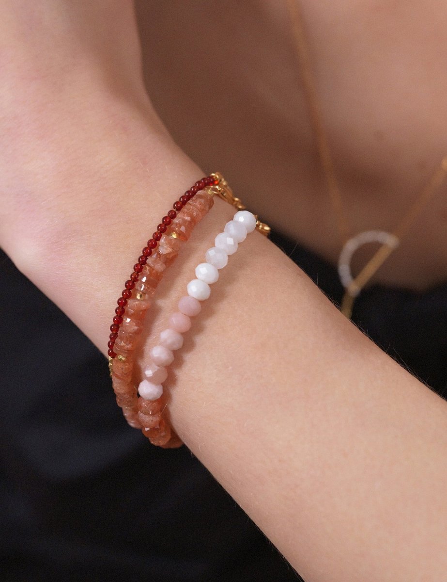 Dainty Fire Ember Core Red Onyx bracelet with spacer beads worn on a wrist, showcasing natural gemstones.
