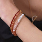 Dainty Fire Ember Core Red Onyx bracelet with spacer beads worn on a wrist, showcasing natural gemstones.