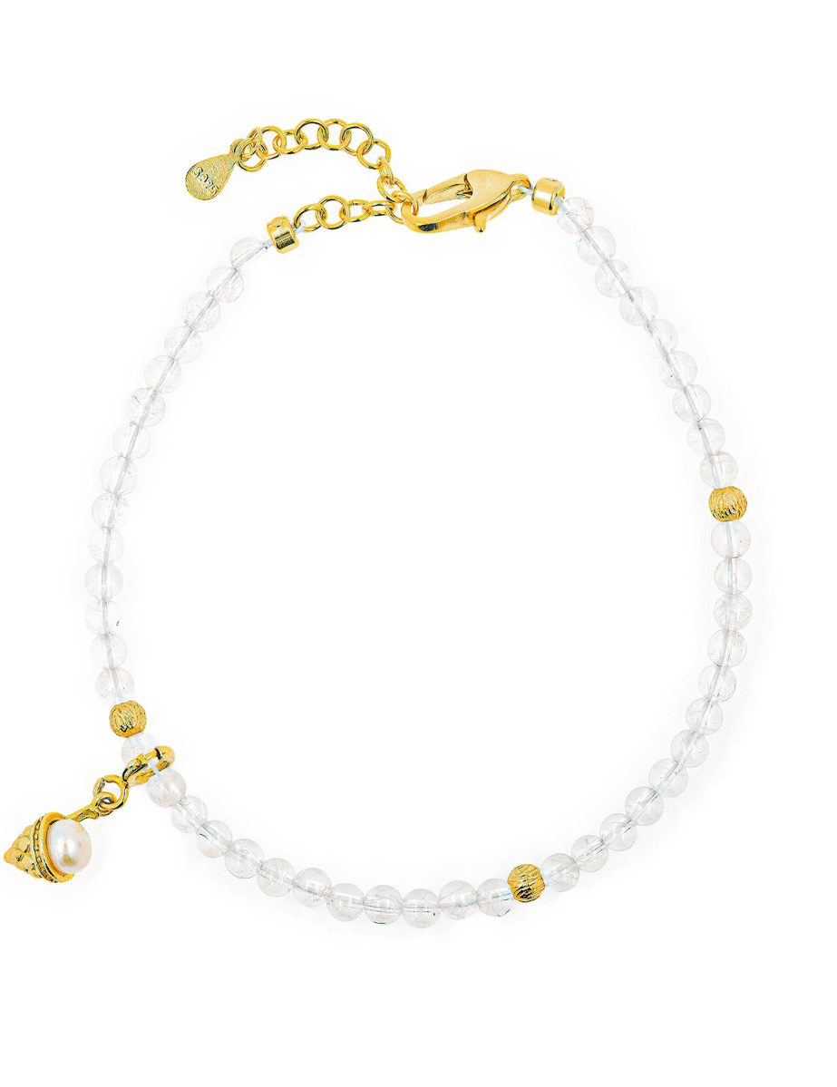 Elegant clear beaded bracelet with gold accents and charm for a chic look.