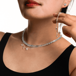 Woman wearing a handcrafted aquamarine faceted necklace with star charms and silver earrings, promoting tranquility.