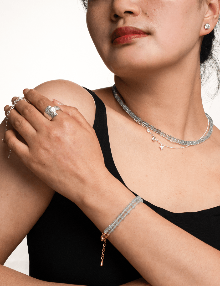 Woman wearing a Health Aquamarine Faceted Necklace and matching jewelry, showcasing tranquility and emotional healing.