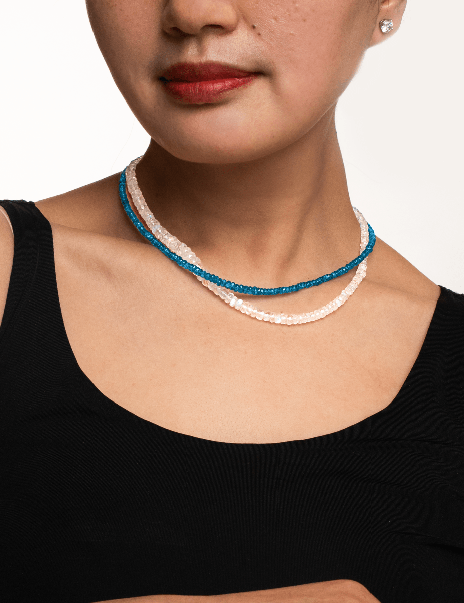 Woman wearing a dainty Blue Apatite necklace with 3mm faceted beads, showcasing strength and energy enhancement.