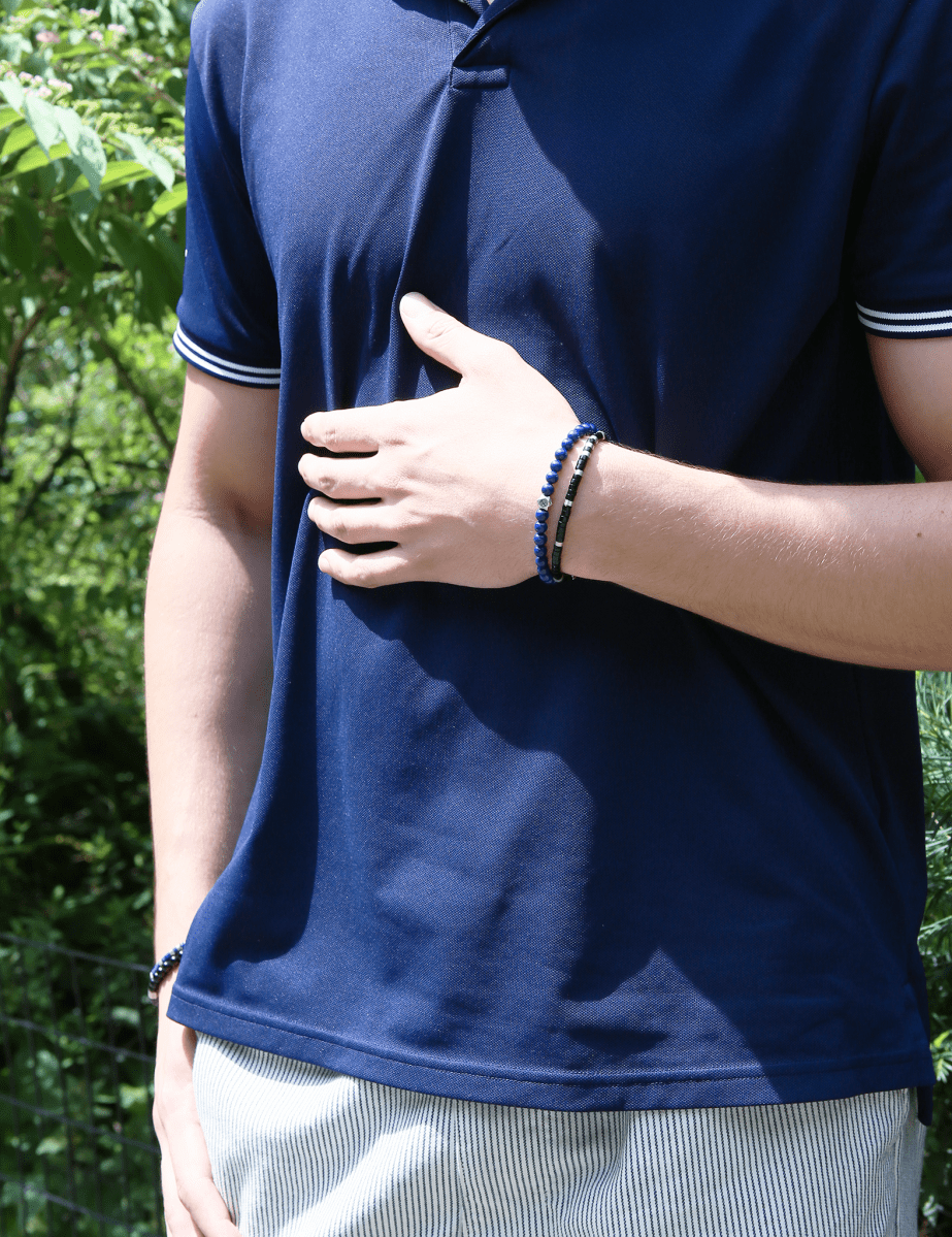 Man wearing a lapis lazuli bracelet with sterling silver zodiac spacer beads, showcasing a stylish accessory.