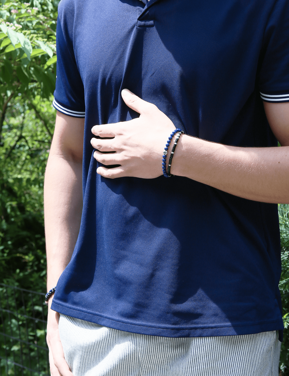 Man wearing a lapis lazuli bracelet with sterling silver zodiac spacer beads, showcasing a stylish accessory.