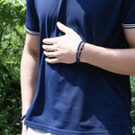 Man wearing a lapis lazuli bracelet with sterling silver zodiac spacer beads, showcasing a stylish accessory.