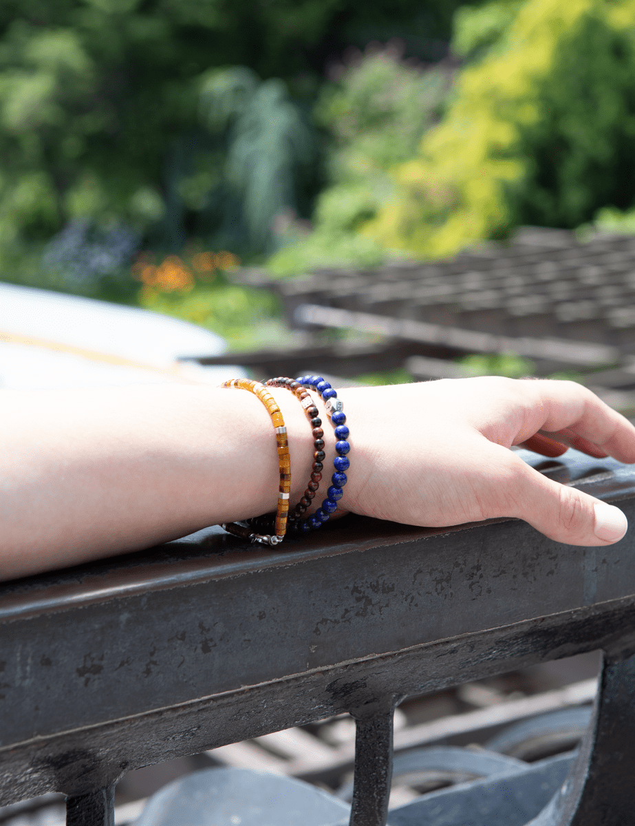 Hand wearing a lapis lazuli bracelet with sterling silver zodiac spacer beads, showcasing the bracelet's beautiful colors.