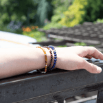 Hand wearing a lapis lazuli bracelet with sterling silver zodiac spacer beads, showcasing the bracelet's beautiful colors.