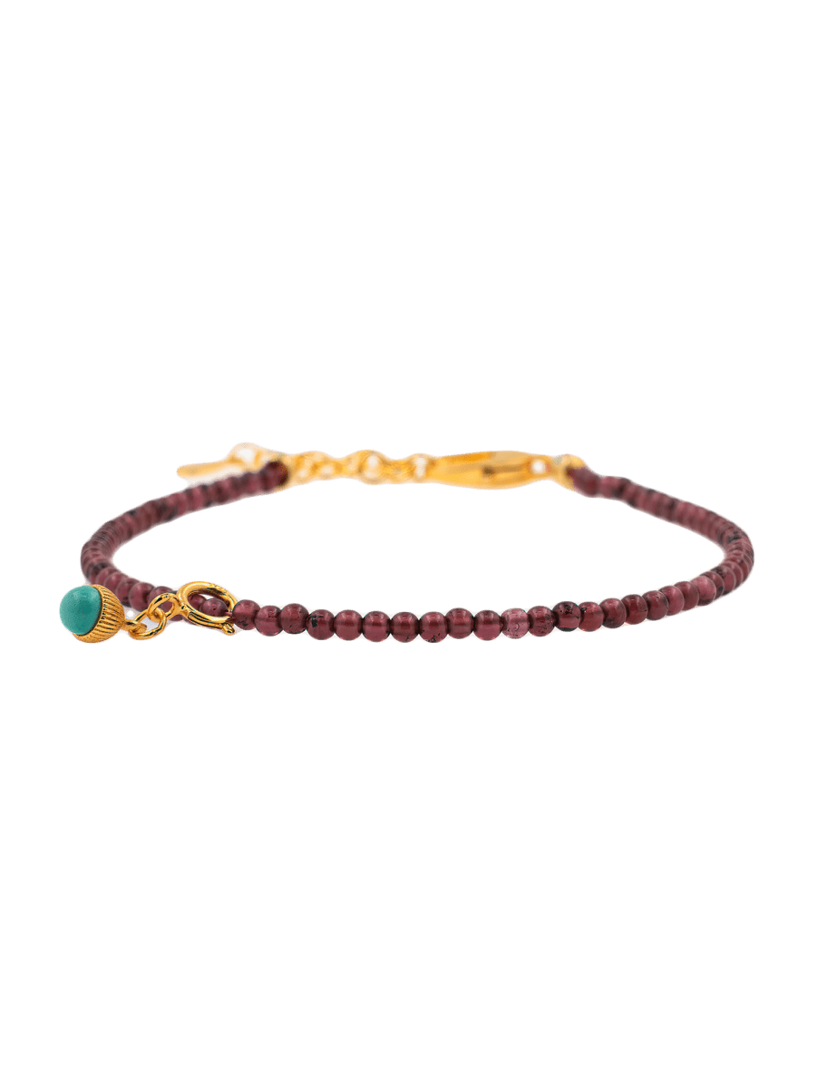 Dainty garnet bracelet with turquoise charm and sterling silver clasp, symbolizing love and protection.