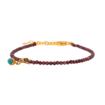 Dainty garnet bracelet with turquoise charm and sterling silver clasp, symbolizing love and protection.