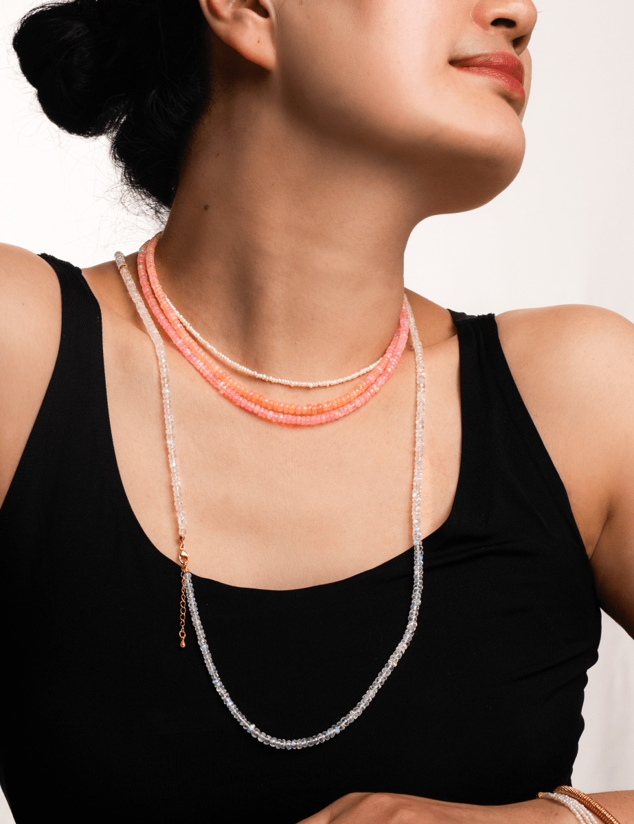 Woman wearing a Love Pink Opal Faceted Dainty Necklace showcasing its soft, rosy glow.