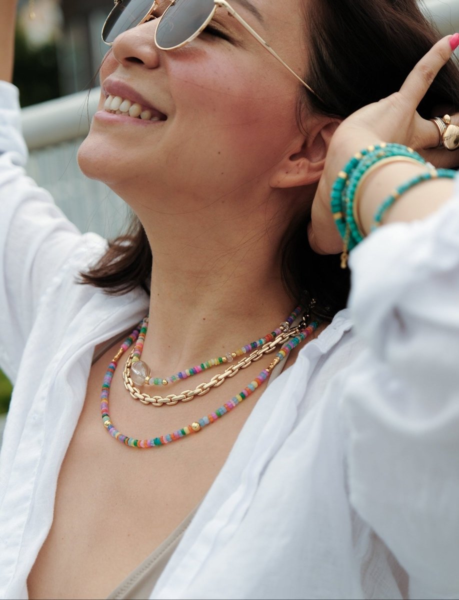 Model wearing MIRA Rainbow Opal & Clear Quartz beaded choker necklace, showcasing vibrant colors and gold-plated accents.