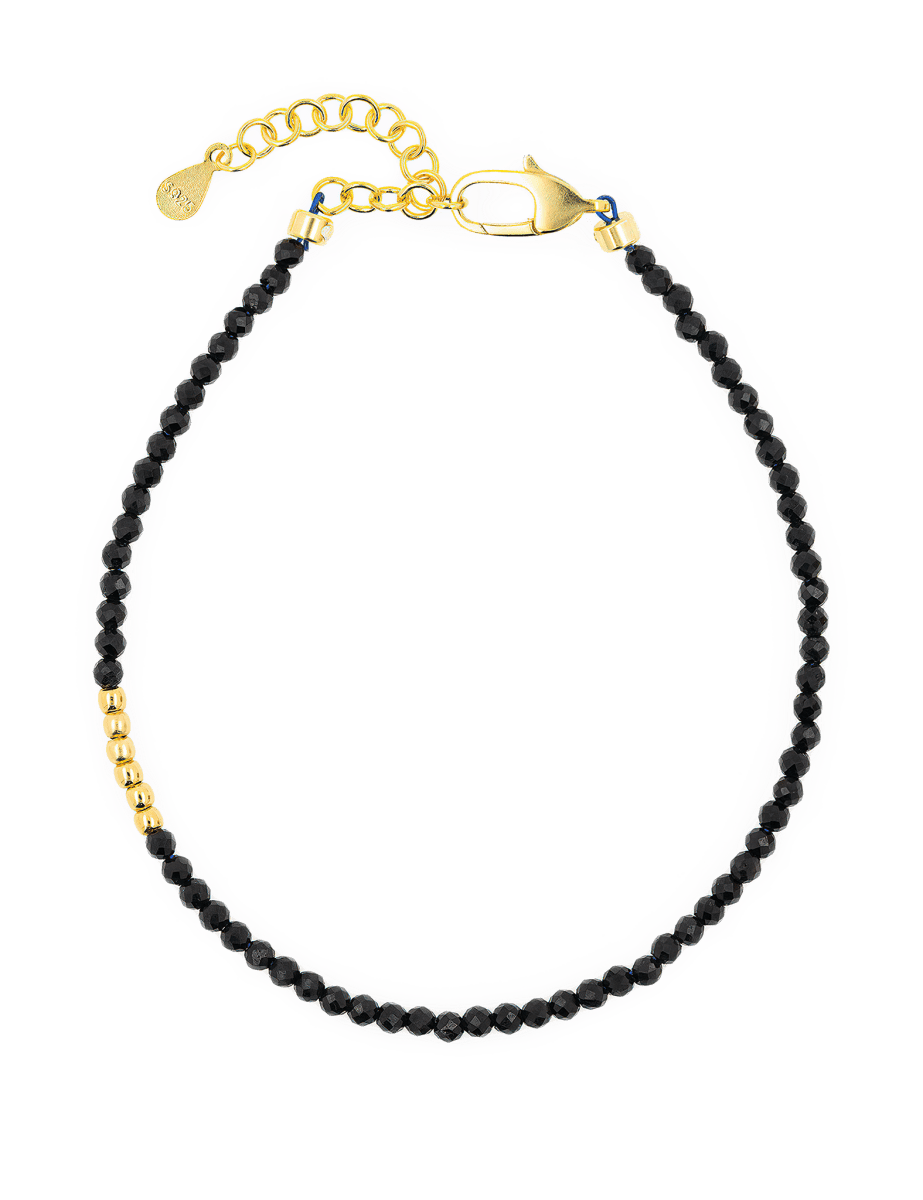 Black Tourmaline faceted bracelet with gold clasp and silver spacer, promoting protection and emotional stability.