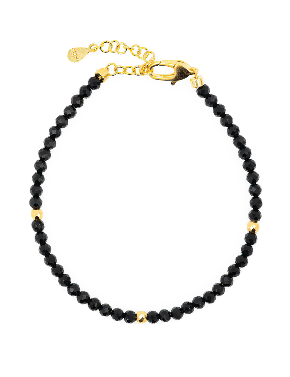 Dainty Black Tourmaline bracelet with gold spacer beads, featuring a secure clasp for elegant protection and grounding.