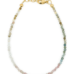 Dainty sterling silver bracelet featuring multicolored tourmaline beads and gold accents for protection and elegance.