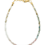 Dainty sterling silver bracelet featuring multicolored tourmaline beads and gold accents for protection and elegance.