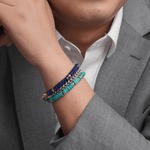 Man wearing a stylish turquoise and gold-plated sterling silver bracelet with a gray suit, showcasing elegance and sophistication.