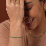 Model wearing a SHANGHAI Tsavorite tube necklace and bracelet in 18K gold, showcasing a minimalist yet vibrant style.