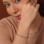 Woman wearing SHANGHAI Emerald Spring Glimmer Beaded Bracelet with 18K Gold accents, showcasing elegance and beauty.