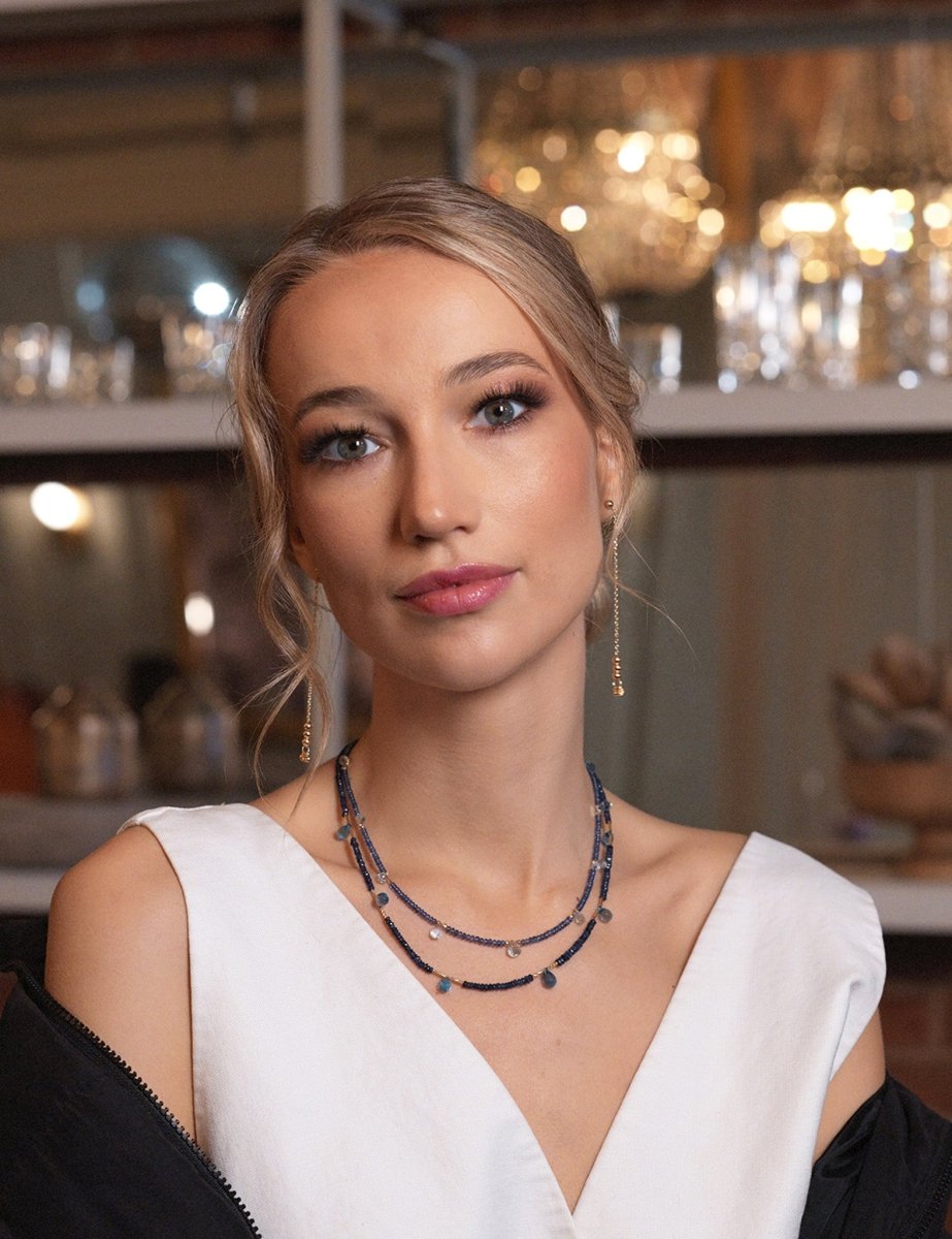 Model showcasing SHANGHAI sapphire and blue topaz drop pendant necklace in elegant setting.