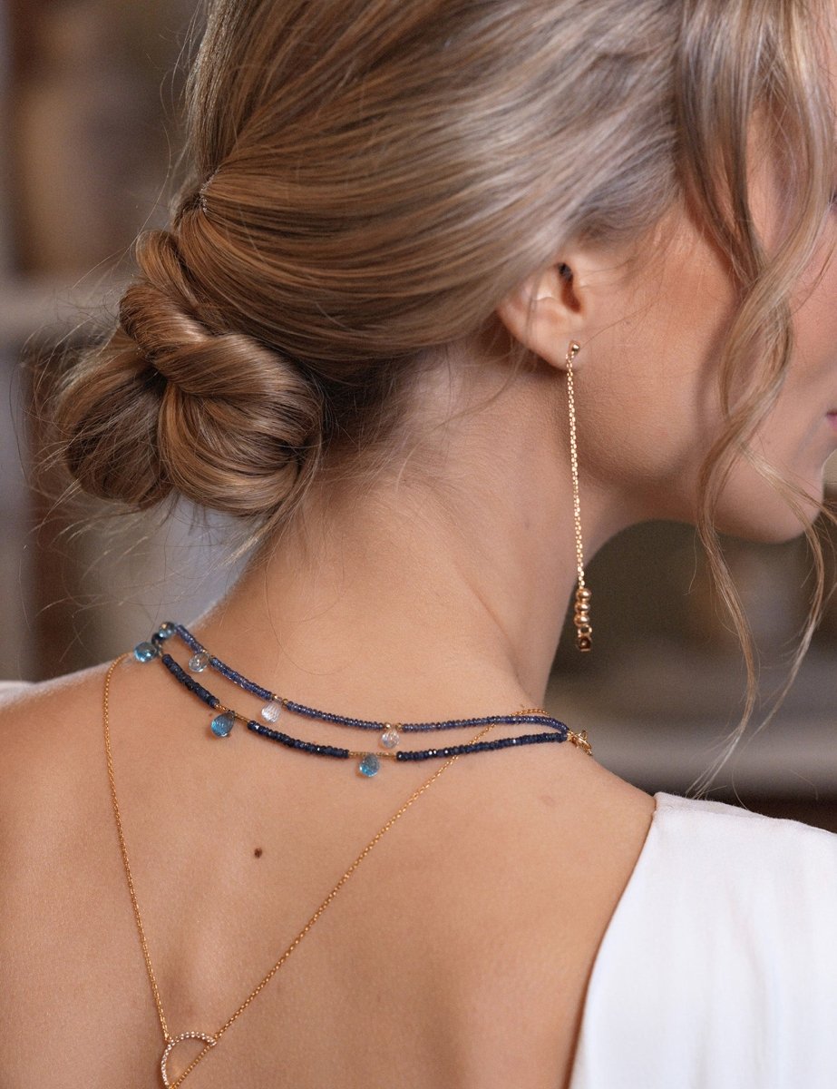 Elegant woman showcasing SHANGHAI Light Sapphire & Blue Topaz necklace with 18K gold, highlighting delicate craftsmanship.