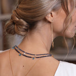 Elegant woman showcasing SHANGHAI Light Sapphire & Blue Topaz necklace with 18K gold, highlighting delicate craftsmanship.