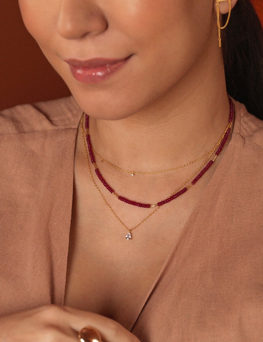 Woman wearing SHANGHAI Ruby Floral Tube Beaded Necklace with 18K Gold accents, showcasing a delicate, vibrant design.